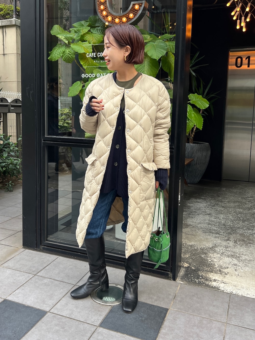 ベージュ系のダウンジャケット/コート、ブルー系のカーディガン/ボレロ、ブラック系のブーツを着用したレディースの冬コーディネートの4枚目の写真
