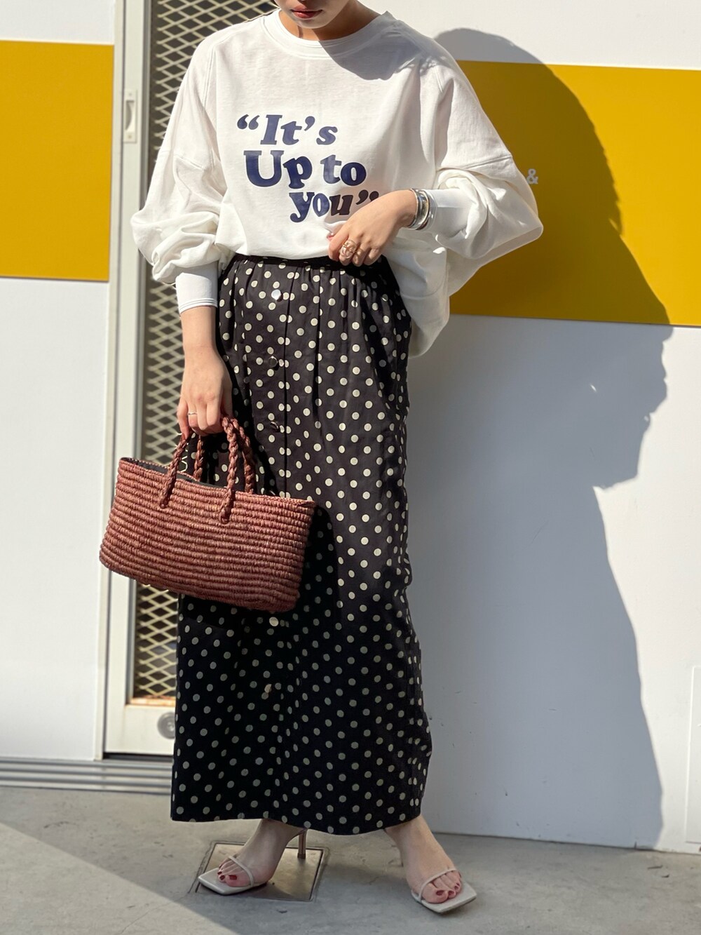 ブラック系のスカート、ホワイト系のTシャツ/カットソー、ベージュ系のサンダルを着用したレディースの冬コーディネートの2枚目の写真
