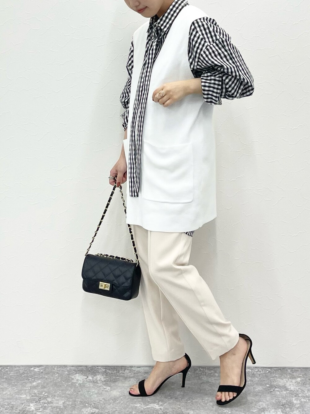 ホワイト系のベスト、ホワイト系のシャツ/ブラウス、ホワイト系のパンツを着用したレディースの冬コーディネートの3枚目の写真
