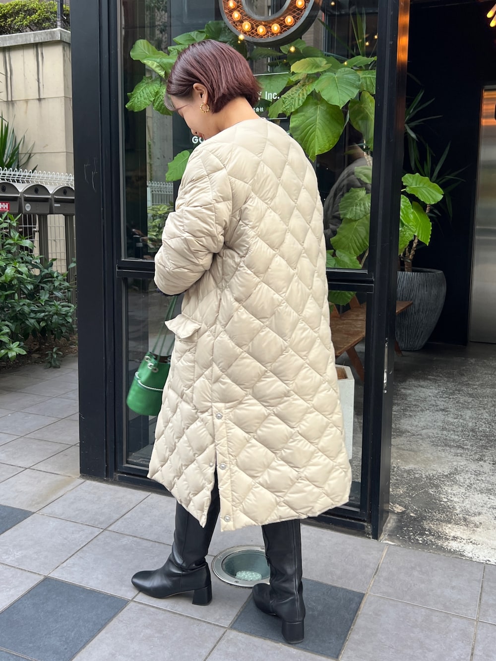 ベージュ系のダウンジャケット/コート、ブルー系のカーディガン/ボレロ、ブラック系のブーツを着用したレディースの冬コーディネートの3枚目の写真