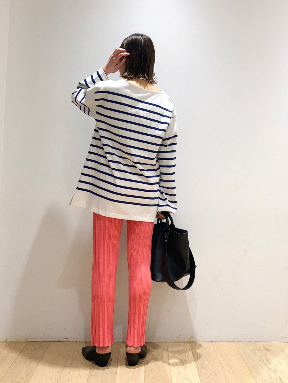 ブルー系のTシャツ/カットソー、ピンク系のパンツ、ブラック系のトートバッグを着用したレディースの春コーディネートの2枚目の写真