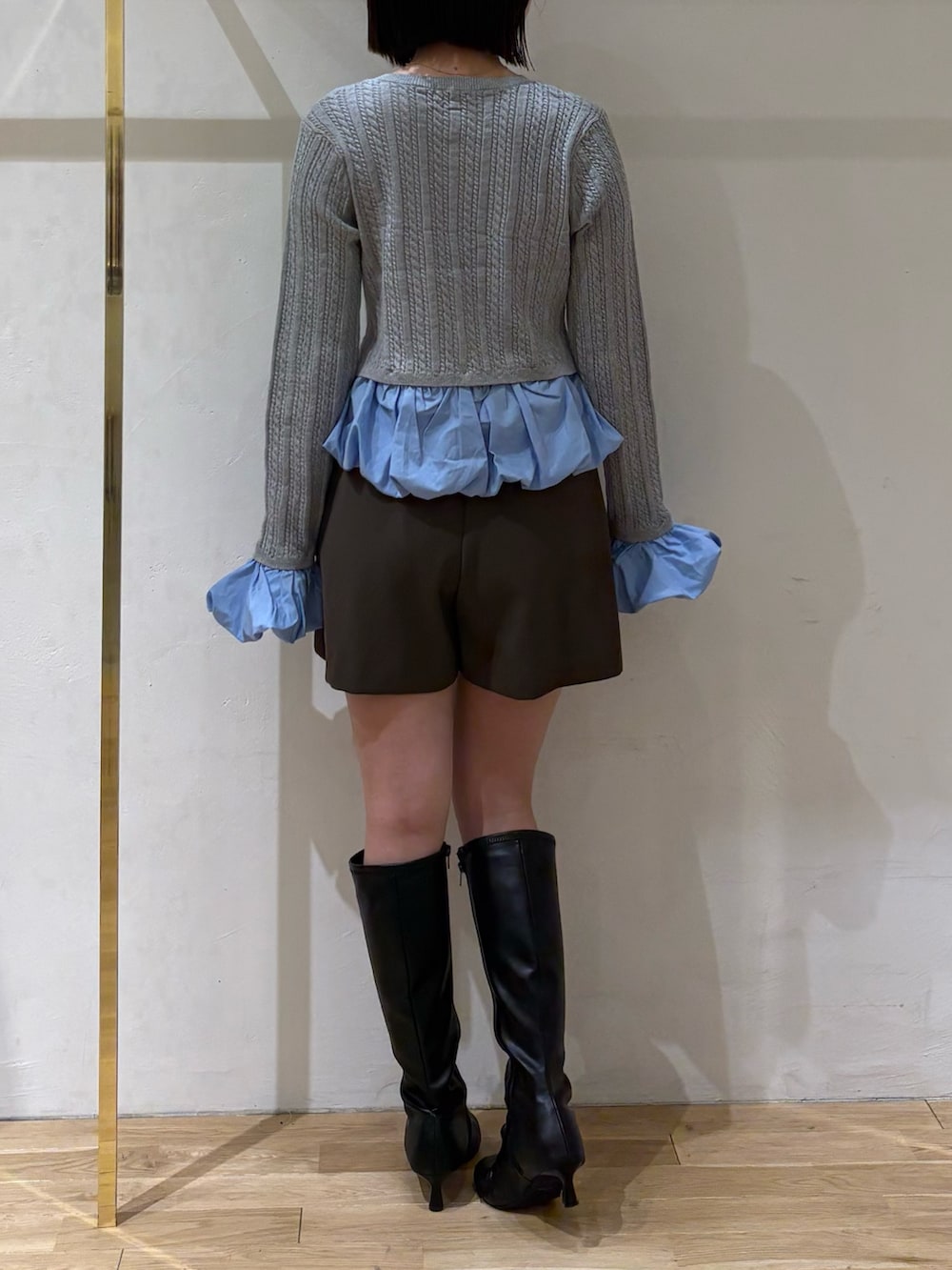 グレー系のニット/セーター、ブラウン系のその他パンツ、ブラック系のブーツを着用したレディースの秋コーディネートの3枚目の写真