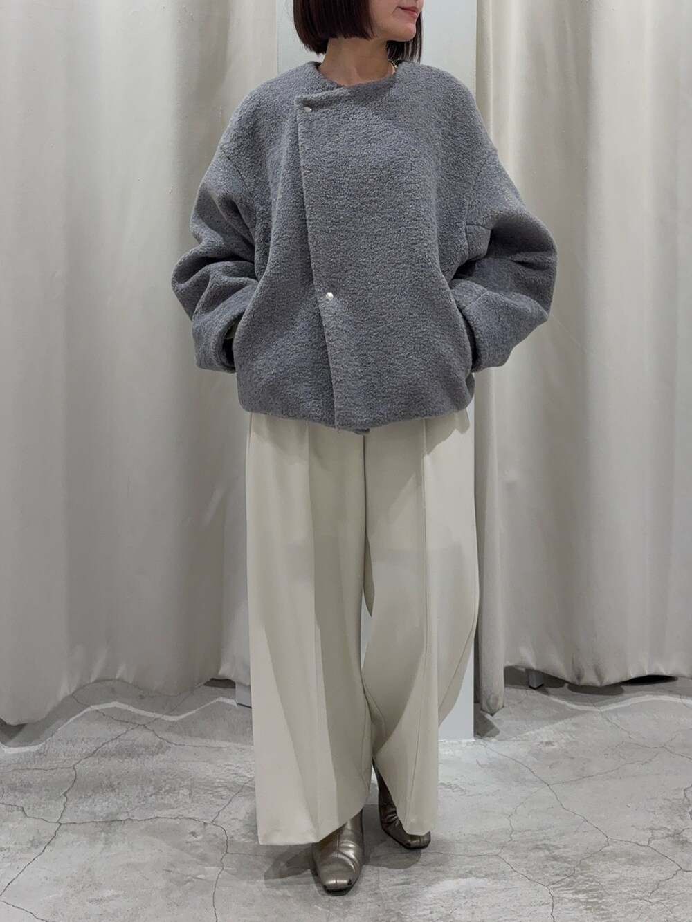 グリーン系のニット/セーター、グレー系のブルゾン、ホワイト系のその他パンツを着用したレディースの冬コーディネートの2枚目の写真