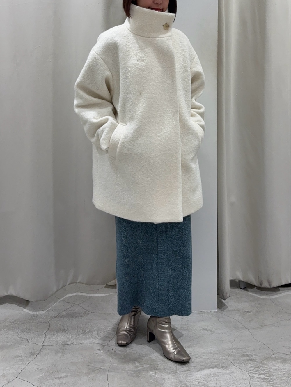 ホワイト系のその他アウター、ブルー系のワンピース、ゴールド系のネックレスを着用したレディースの冬コーディネートの6枚目の写真