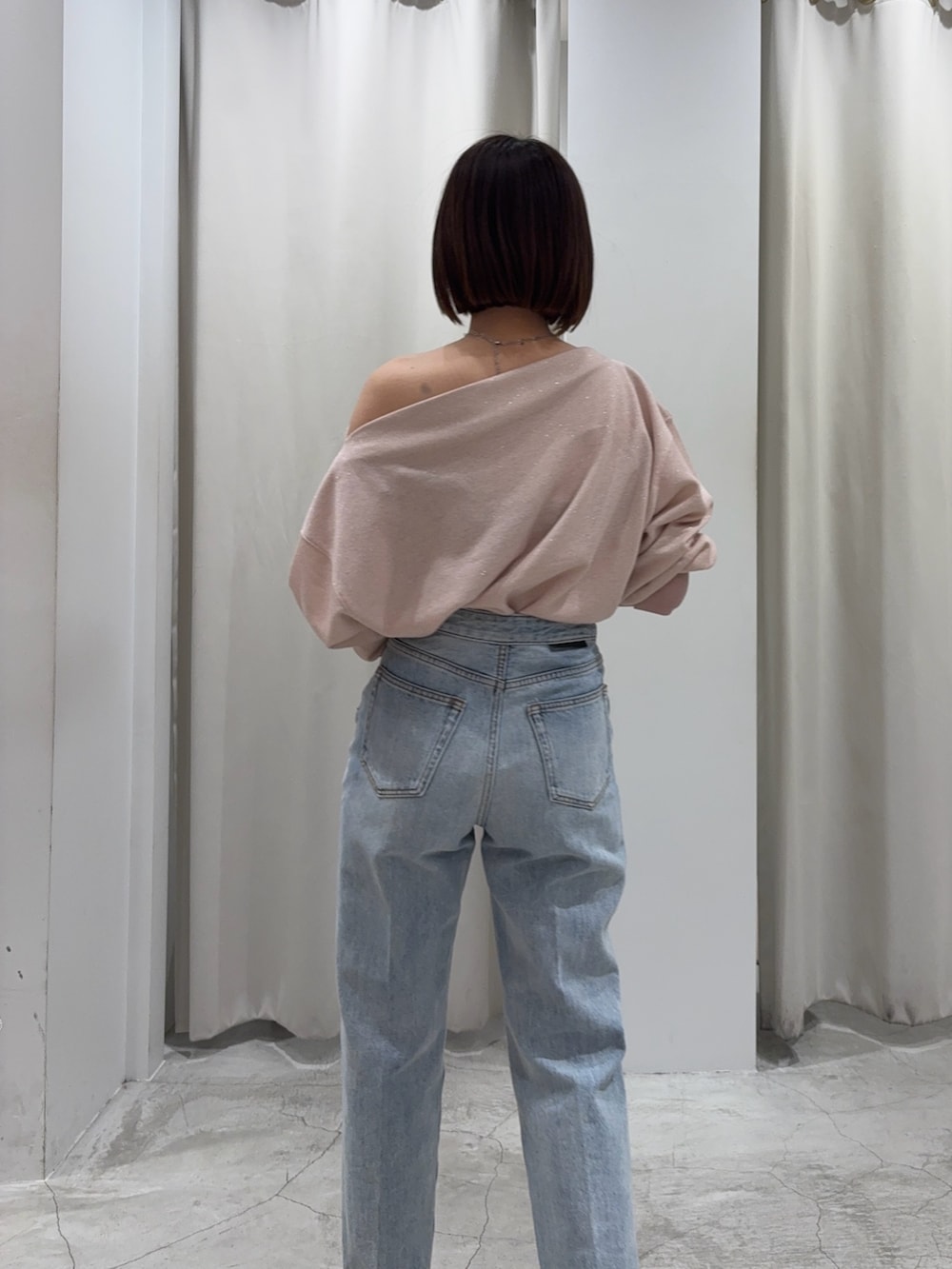 ピンク系のスウェット、ブルー系のデニムパンツ、その他のパンプスを着用したレディースの春コーディネートの4枚目の写真