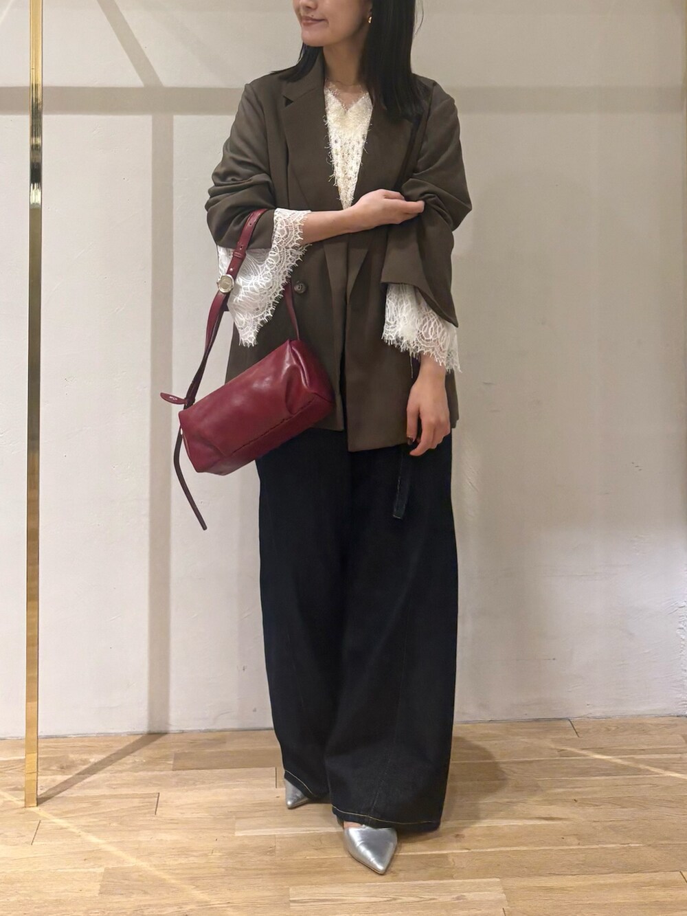 ホワイト系のニット/セーター、ブラウン系のテーラードジャケット、ブルー系のデニムパンツを着用したレディースの秋コーディネートの8枚目の写真