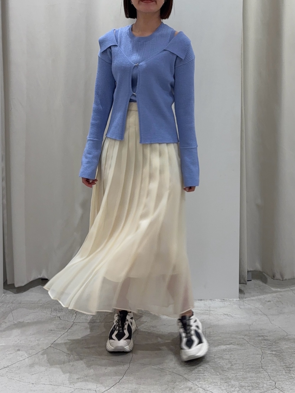 ブルー系のアンサンブル、ホワイト系のスカート、グレー系のスニーカーを着用したレディースの冬コーディネートの7枚目の写真
