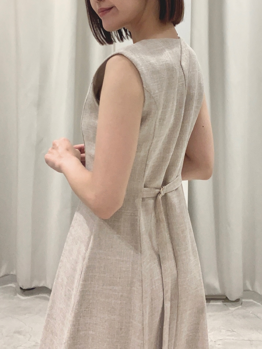 ベージュ系のワンピース、ホワイト系のショルダーバッグ、ホワイト系のパンプスを着用したレディースの夏コーディネートの3枚目の写真