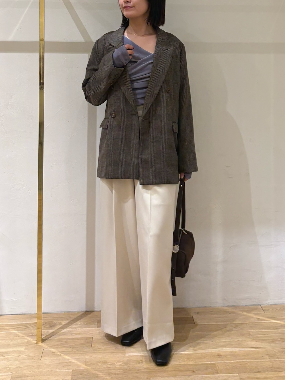 ブルー系のTシャツ/カットソー、ホワイト系のその他パンツ、ブラウン系のハンドバッグを着用したレディースの秋コーディネートの6枚目の写真