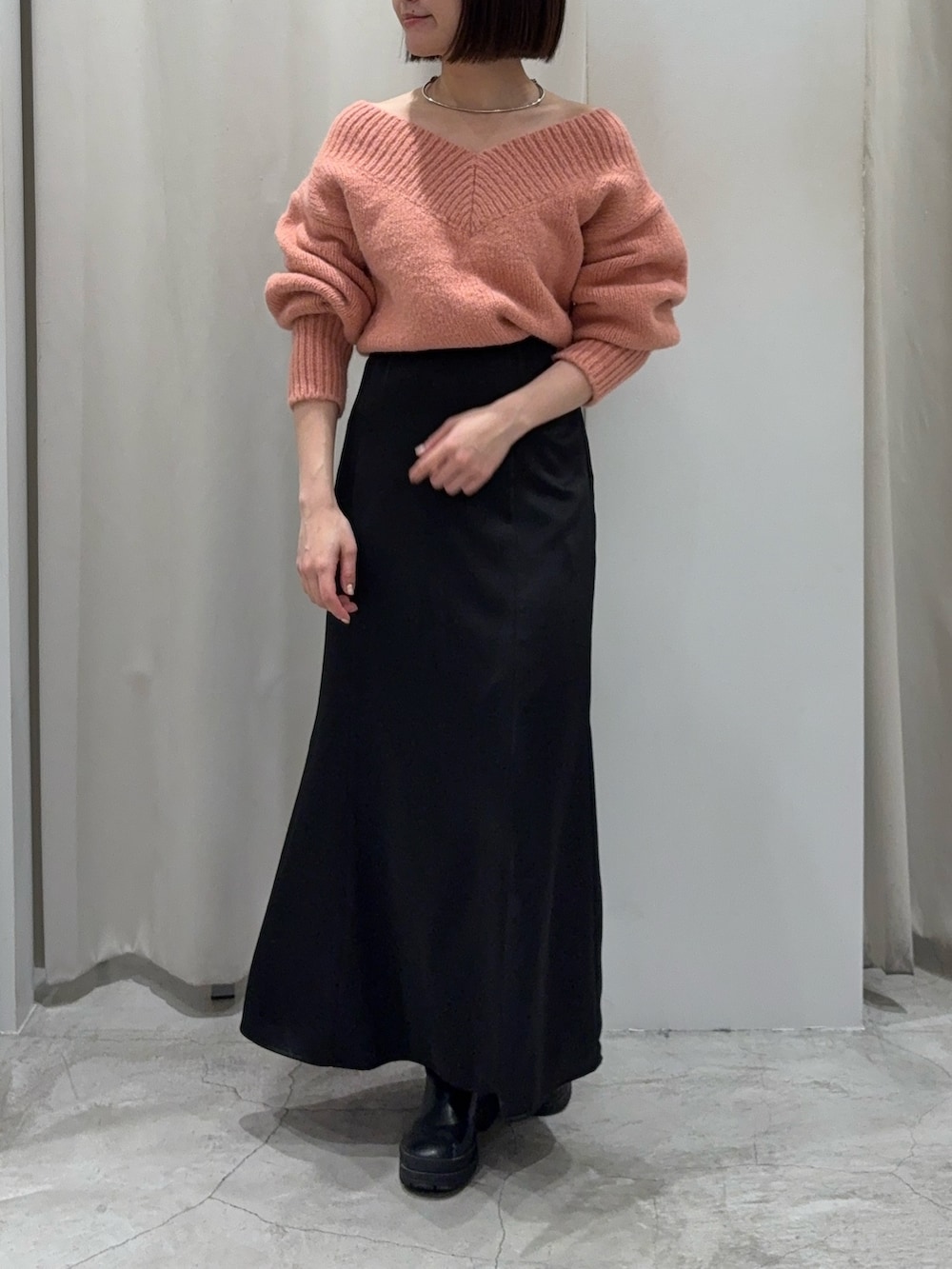 ブラック系のスカート、ピンク系のニット/セーター、ブラック系のショルダーバッグを着用したレディースの冬コーディネートの4枚目の写真
