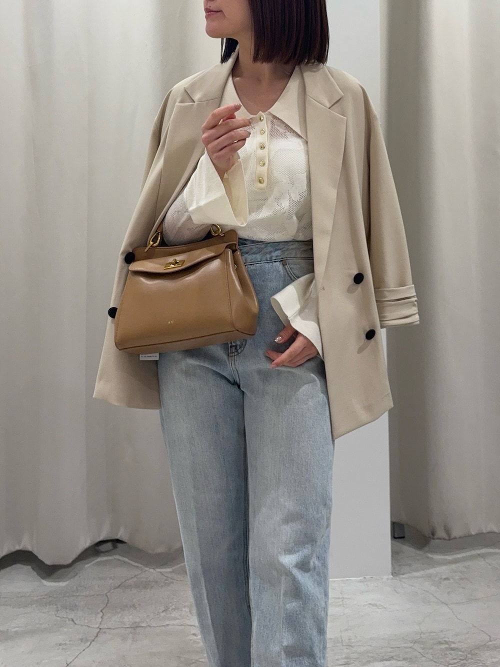 ホワイト系のニット/セーター、ブルー系のデニムパンツ、ホワイト系のサンダルを着用したレディースの春コーディネートの4枚目の写真