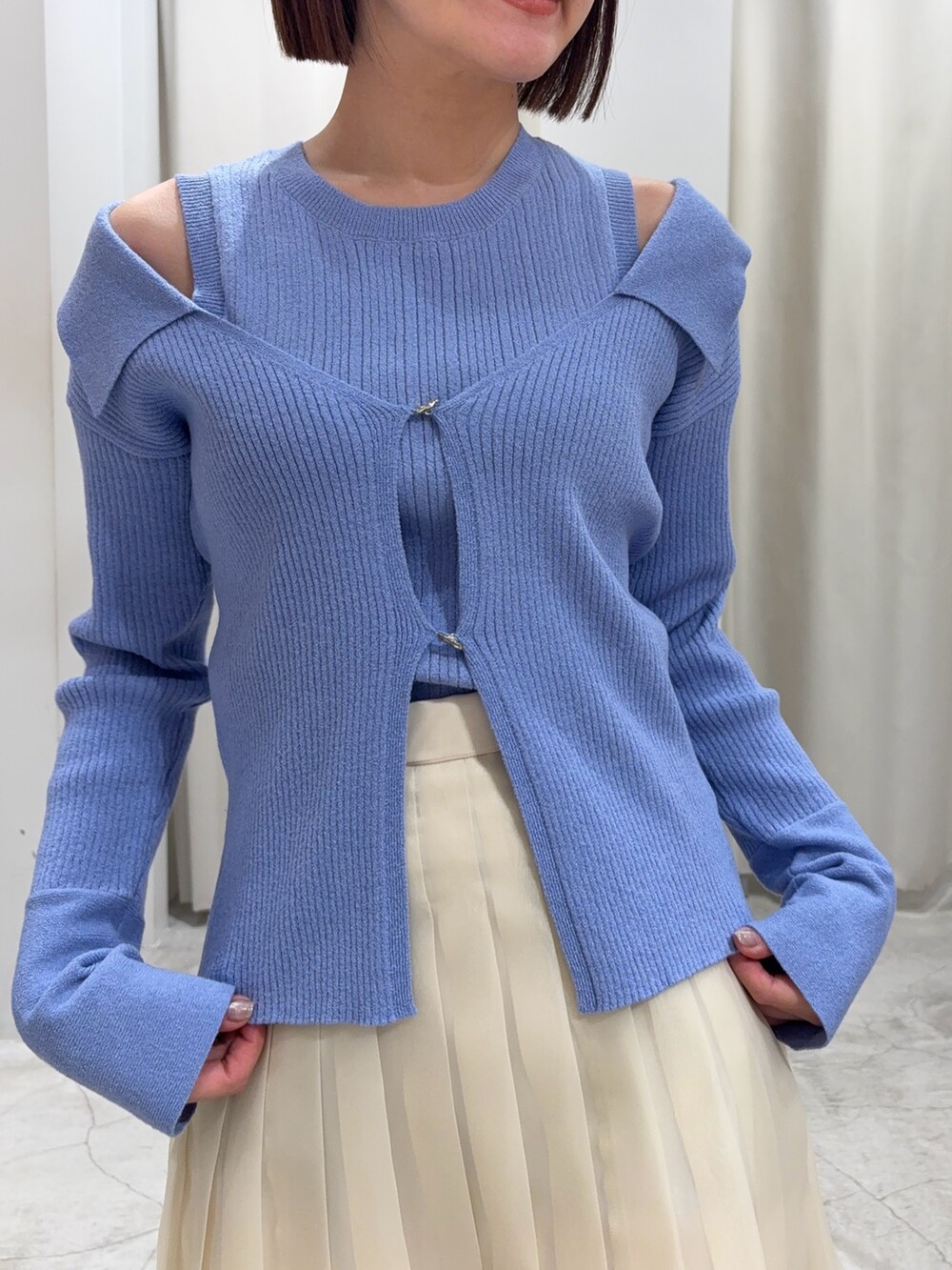 ブルー系のアンサンブル、ホワイト系のスカート、グレー系のスニーカーを着用したレディースの冬コーディネートの3枚目の写真