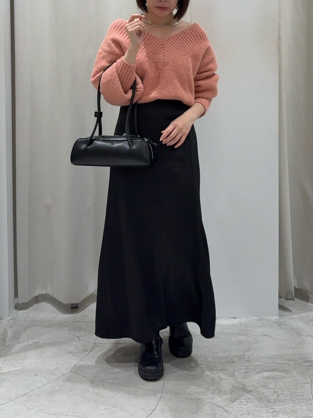 ブラック系のスカート、ピンク系のニット/セーター、ブラック系のショルダーバッグを着用したレディースの冬コーディネートの6枚目の写真