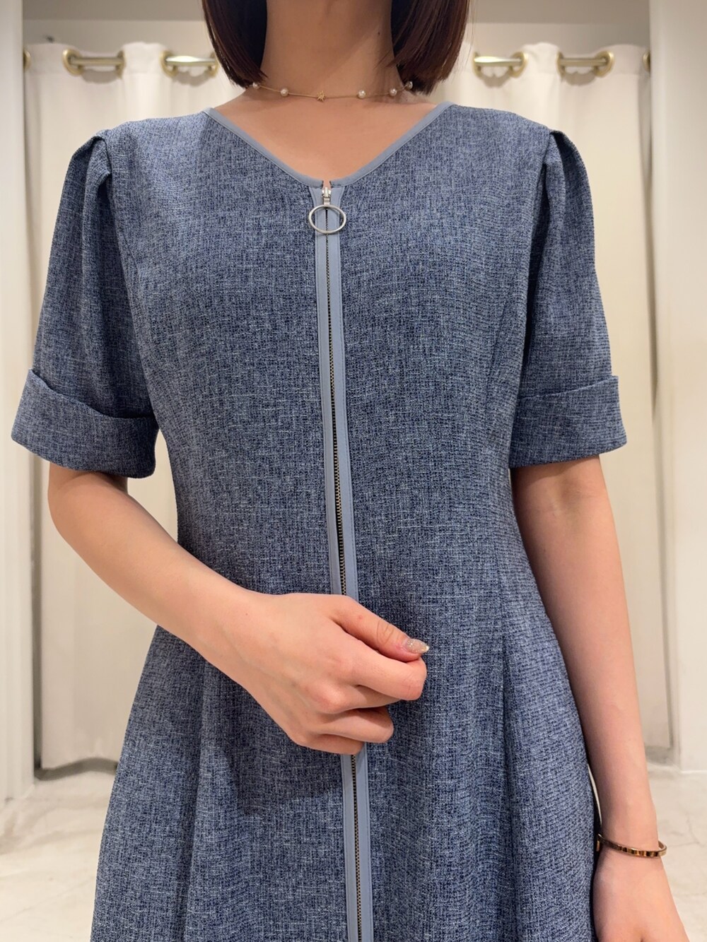 ブルー系のワンピース、ホワイト系のサンダル、ゴールド系のネックレスを着用したレディースの春コーディネートの2枚目の写真