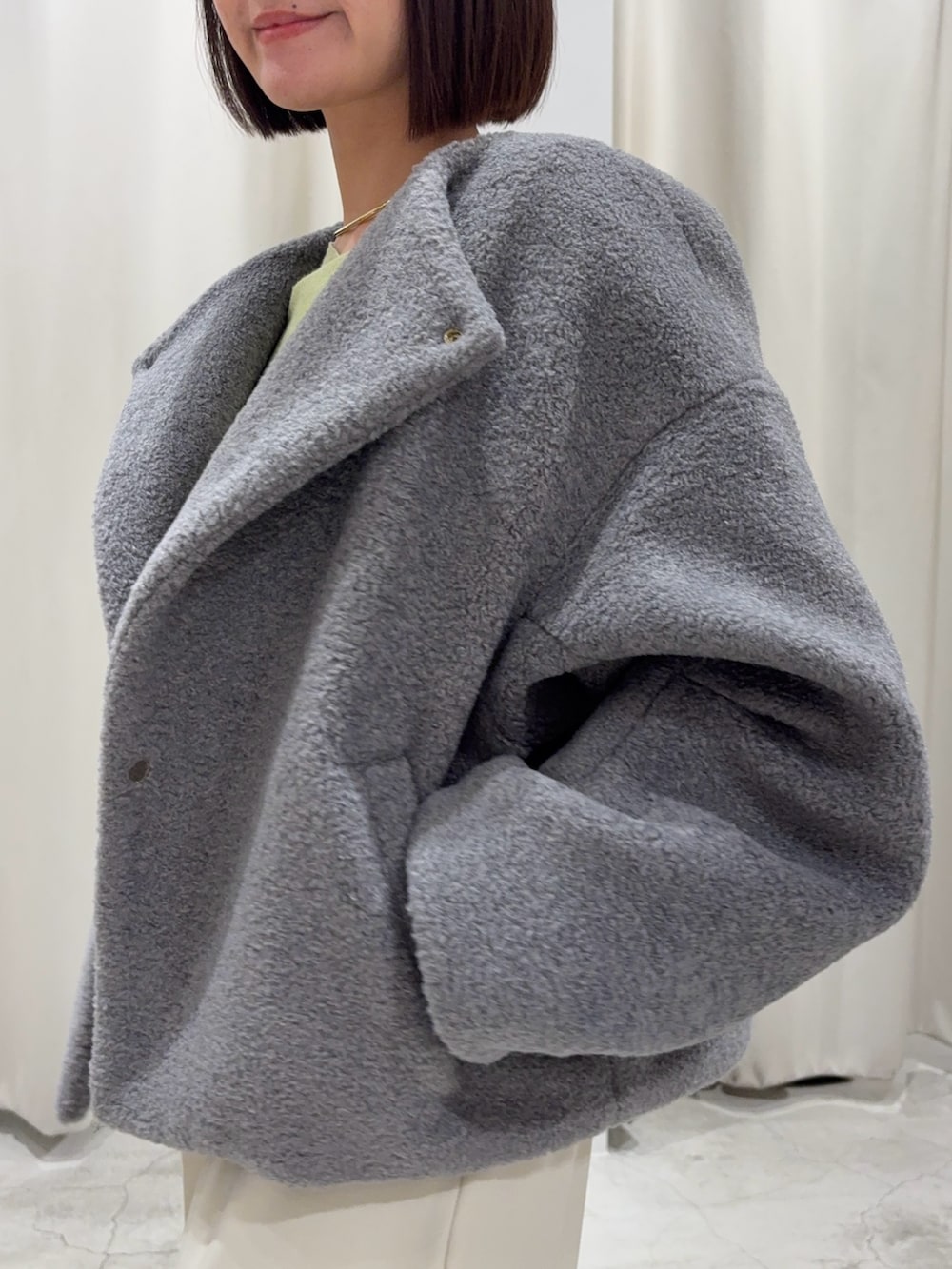 グリーン系のニット/セーター、グレー系のブルゾン、ホワイト系のその他パンツを着用したレディースの冬コーディネートの5枚目の写真