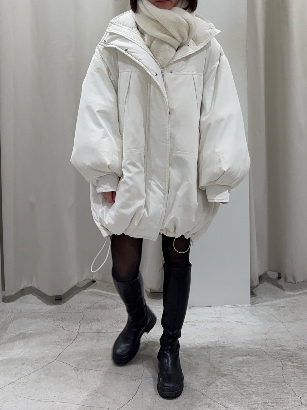 ブラック系のショルダーバッグ、グレー系のスカート、ホワイト系のダウンジャケット/コートを着用したレディースの冬コーディネートの5枚目の写真