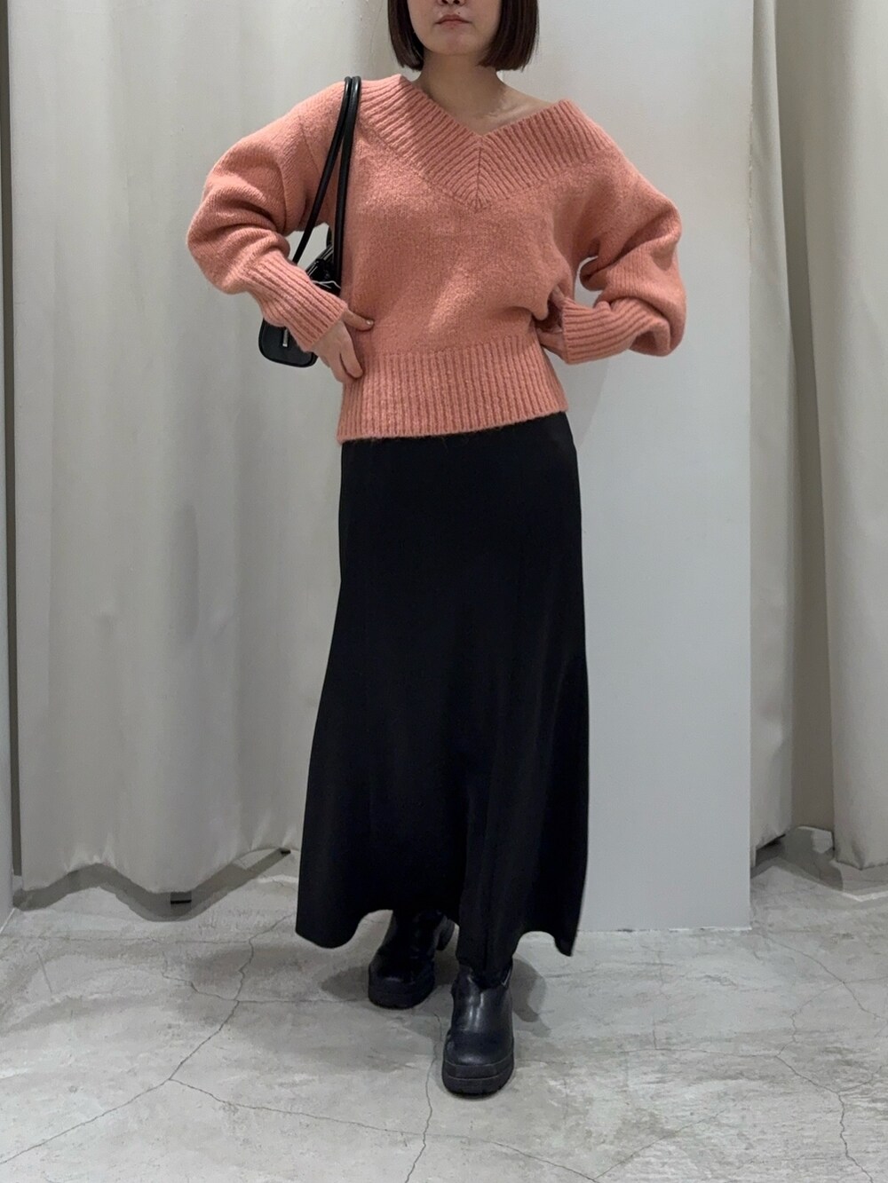 ブラック系のスカート、ピンク系のニット/セーター、ブラック系のショルダーバッグを着用したレディースの冬コーディネートの8枚目の写真