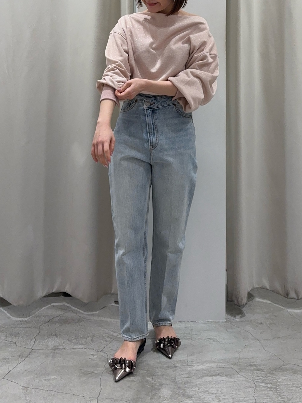 ピンク系のスウェット、ブルー系のデニムパンツ、その他のパンプスを着用したレディースの春コーディネートの2枚目の写真