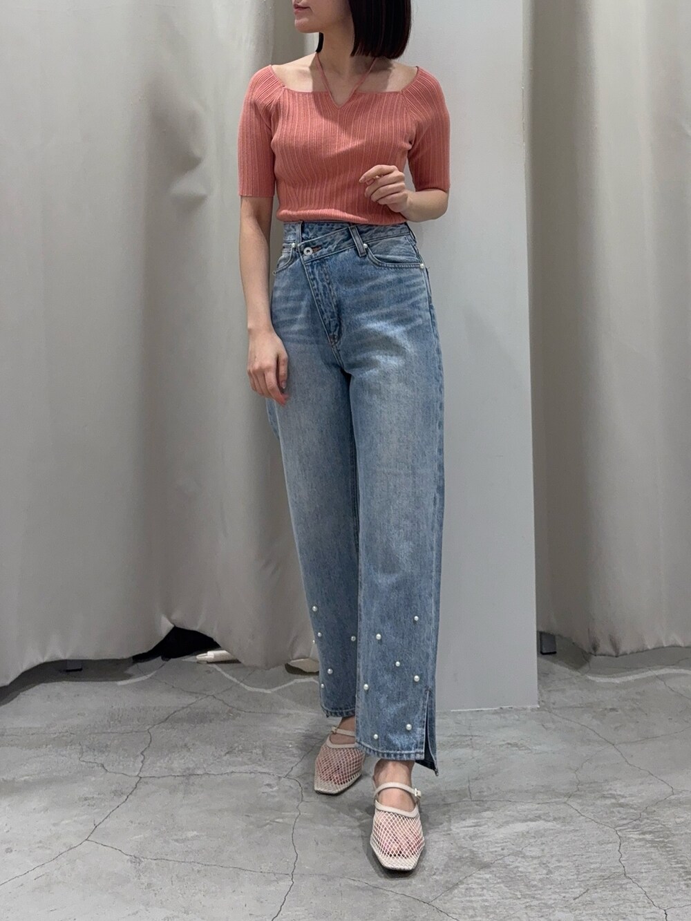 ブルー系のデニムパンツ、ホワイト系のサンダル、ピンク系のニット/セーターを着用したレディースの春コーディネートの3枚目の写真