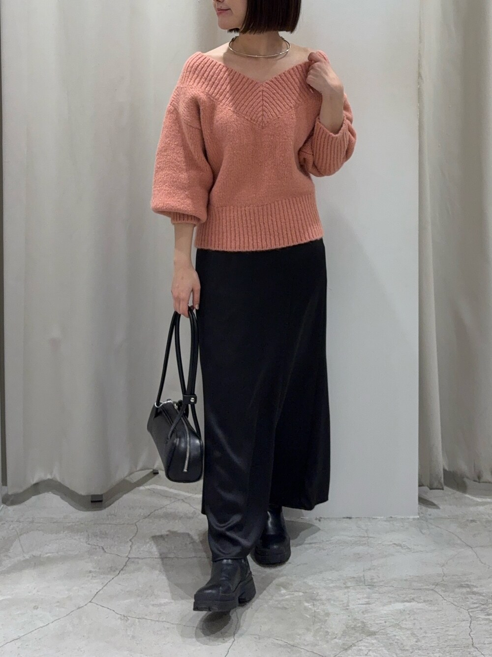 ブラック系のスカート、ピンク系のニット/セーター、ブラック系のショルダーバッグを着用したレディースの冬コーディネートの7枚目の写真