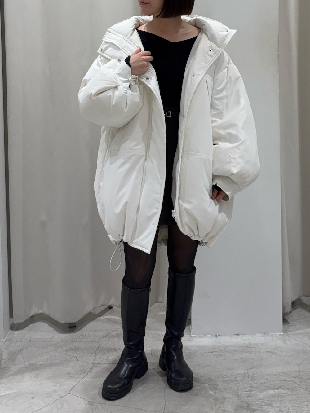 ブラック系のショルダーバッグ、グレー系のスカート、ホワイト系のダウンジャケット/コートを着用したレディースの冬コーディネートの7枚目の写真