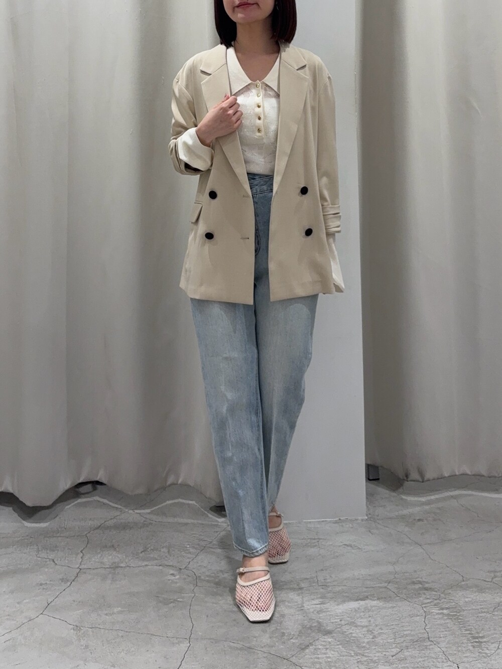 ホワイト系のニット/セーター、ブルー系のデニムパンツ、ホワイト系のサンダルを着用したレディースの春コーディネートの5枚目の写真