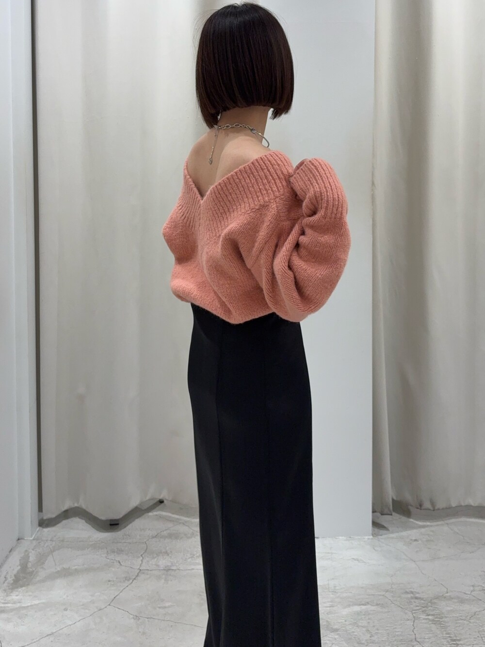 ブラック系のスカート、ピンク系のニット/セーター、ブラック系のショルダーバッグを着用したレディースの冬コーディネートの3枚目の写真