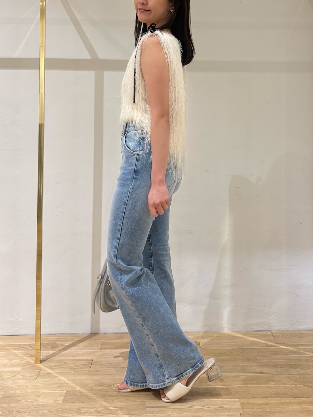 ホワイト系のTシャツ/カットソー、ブルー系のデニムパンツ、シルバー系のハンドバッグを着用したレディースの夏コーディネートの2枚目の写真