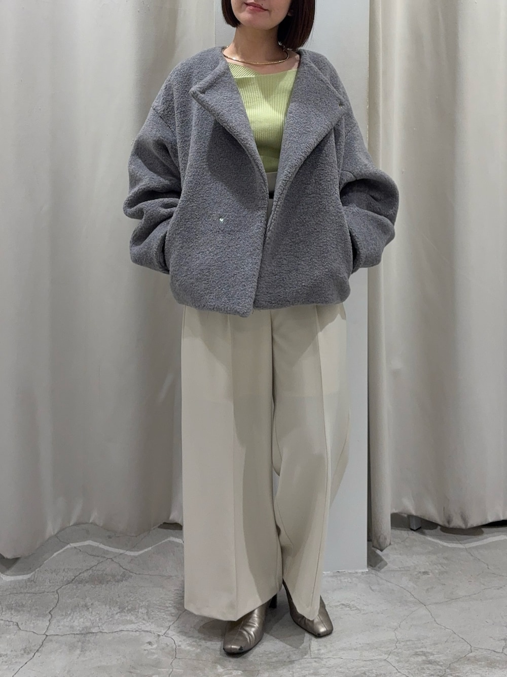 グリーン系のニット/セーター、グレー系のブルゾン、ホワイト系のその他パンツを着用したレディースの冬コーディネートの9枚目の写真