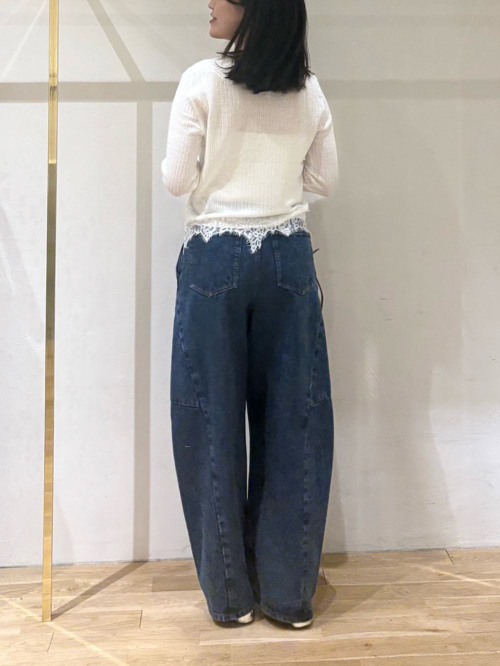 ホワイト系のカーディガン/ボレロ、ブルー系のデニムパンツ、レッド系のハンドバッグを着用したレディースの秋コーディネートの2枚目の写真