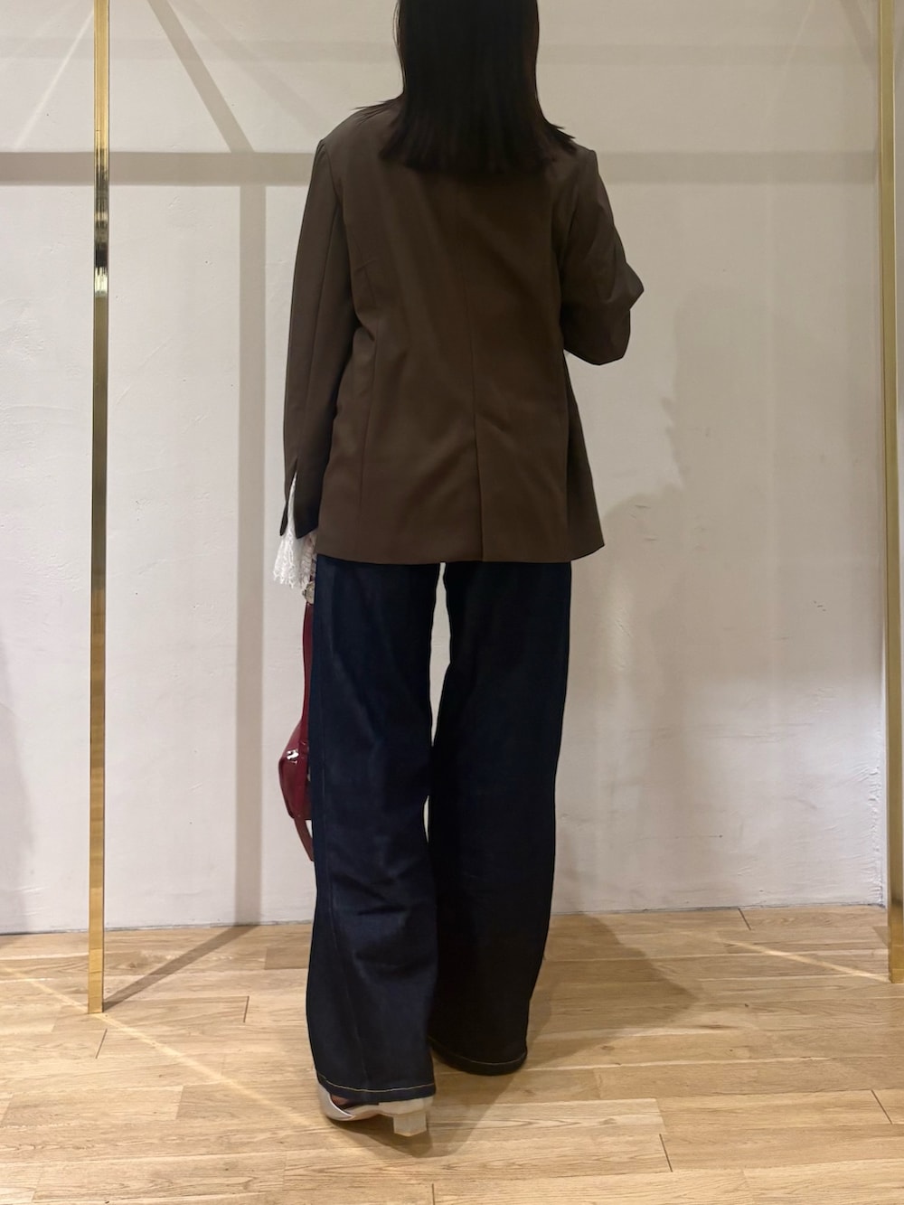 ホワイト系のニット/セーター、ブラウン系のテーラードジャケット、ブルー系のデニムパンツを着用したレディースの秋コーディネートの2枚目の写真