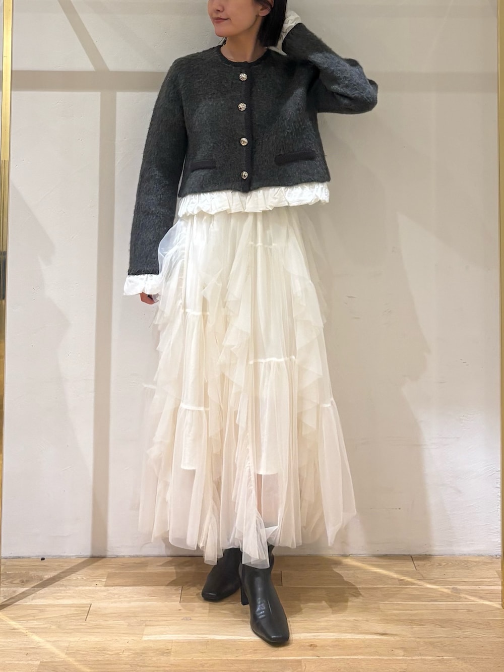 グレー系のノーカラージャケット、ホワイト系のスカート、ブラック系のブルゾンを着用したレディースの秋コーディネートの7枚目の写真