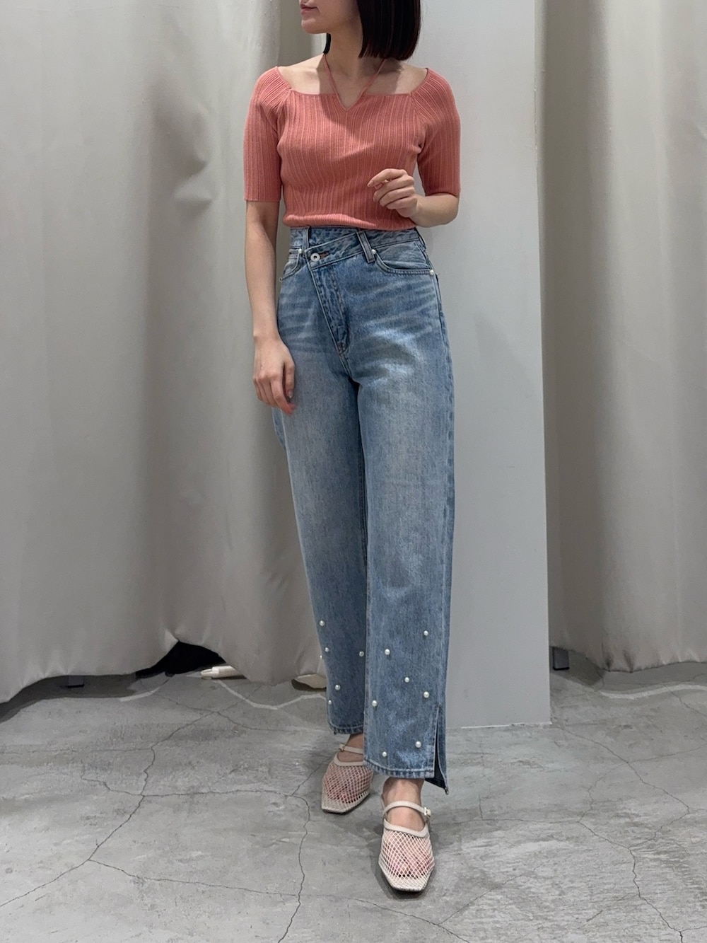 ピンク系のニット/セーター、ブルー系のデニムパンツ、ホワイト系のサンダルを着用したレディースの春コーディネートの2枚目の写真