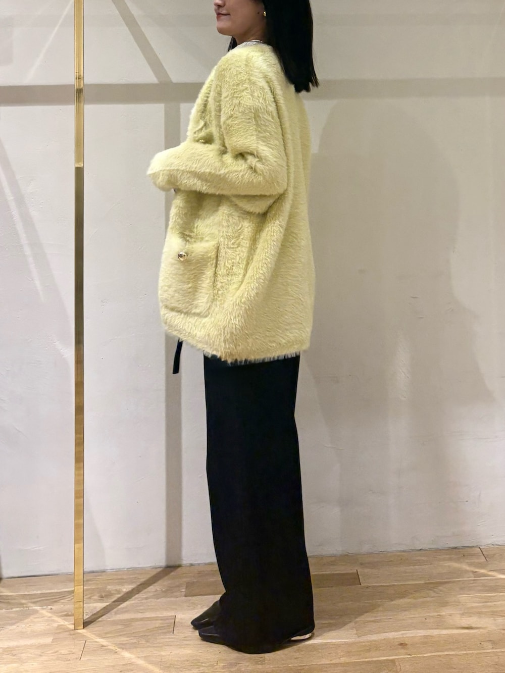 ブラック系のデニムパンツ、ホワイト系のTシャツ/カットソー、イエロー系のカーディガン/ボレロを着用したレディースの秋コーディネートの2枚目の写真