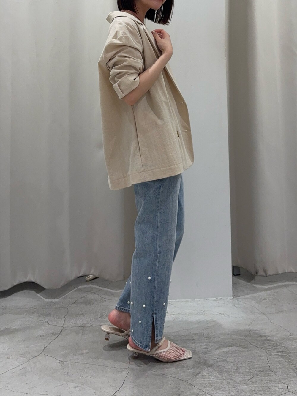 ブルー系のデニムパンツ、ホワイト系のサンダル、ピンク系のニット/セーターを着用したレディースの春コーディネートの2枚目の写真