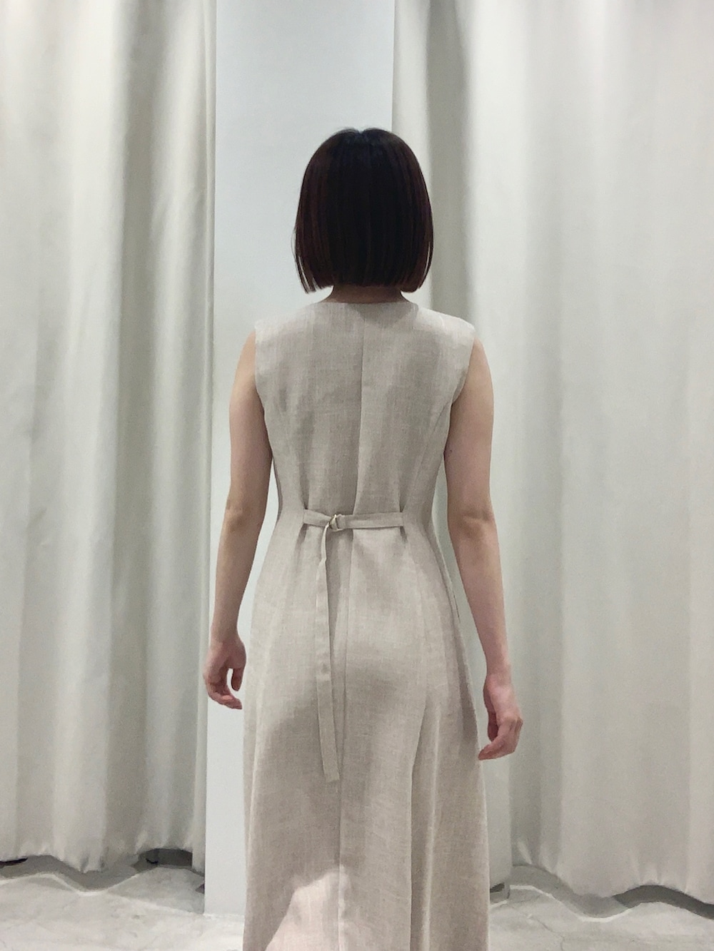 ベージュ系のワンピース、ホワイト系のショルダーバッグ、ホワイト系のパンプスを着用したレディースの夏コーディネートの4枚目の写真