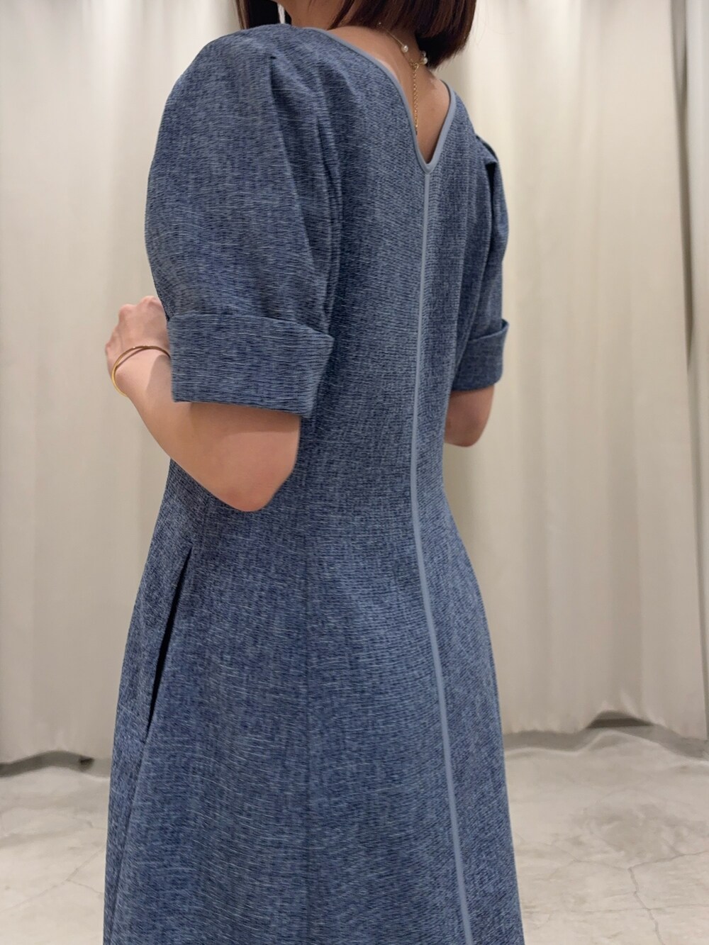 ブルー系のワンピース、ホワイト系のサンダル、ゴールド系のネックレスを着用したレディースの春コーディネートの4枚目の写真