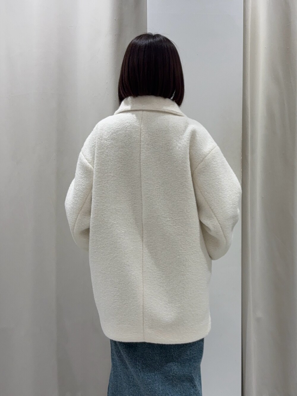 ホワイト系のその他アウター、ブルー系のワンピース、ゴールド系のネックレスを着用したレディースの冬コーディネートの3枚目の写真