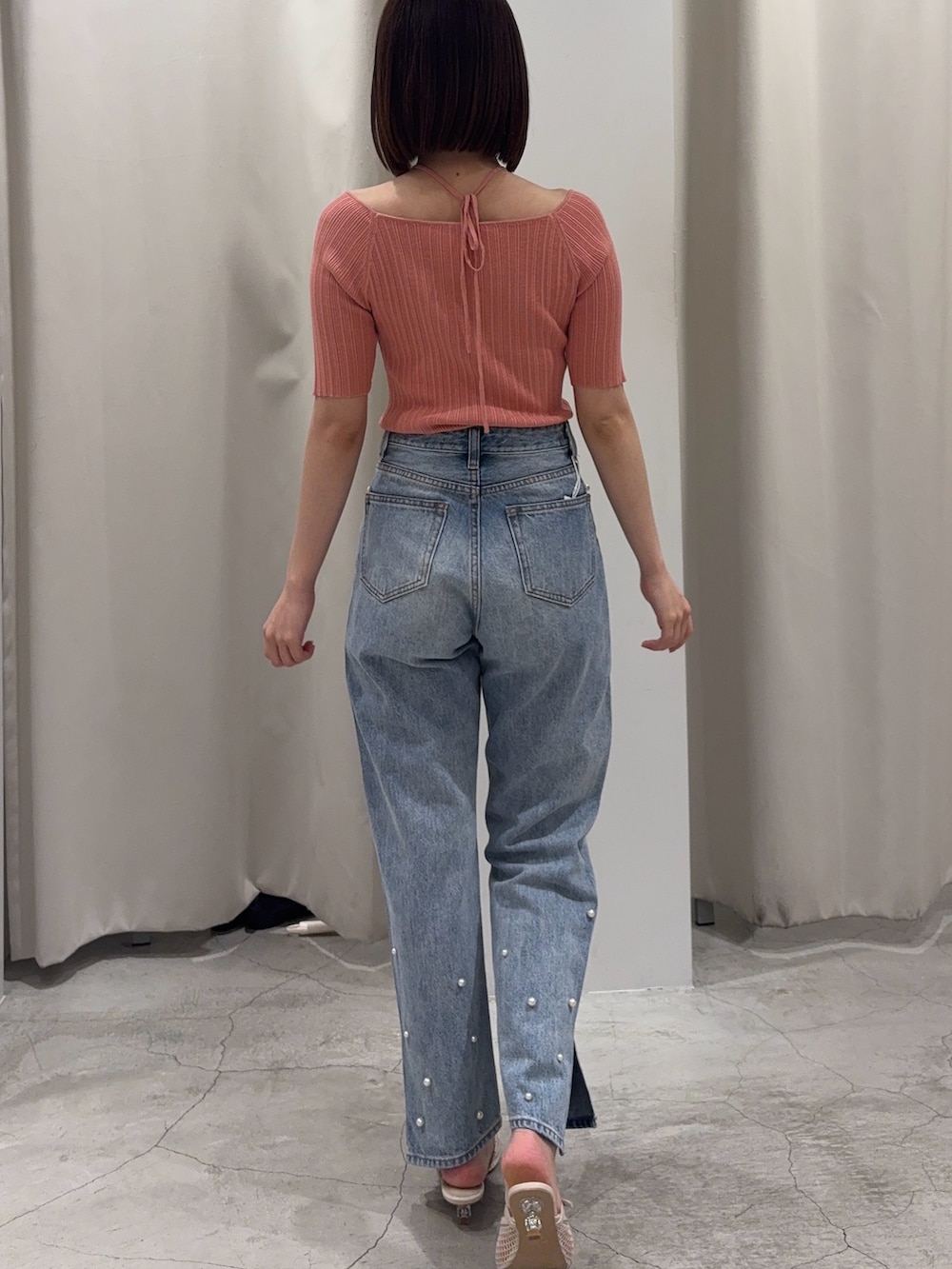 ピンク系のニット/セーター、ブルー系のデニムパンツ、ホワイト系のサンダルを着用したレディースの春コーディネートの3枚目の写真