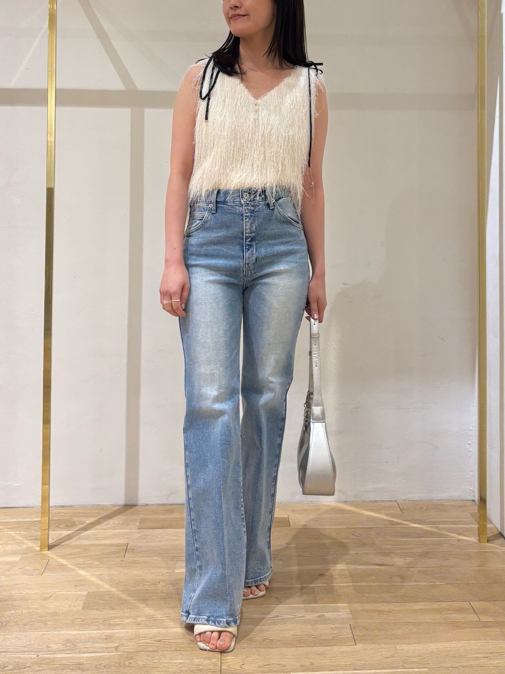 ホワイト系のTシャツ/カットソー、ブルー系のデニムパンツ、シルバー系のハンドバッグを着用したレディースの夏コーディネートの5枚目の写真