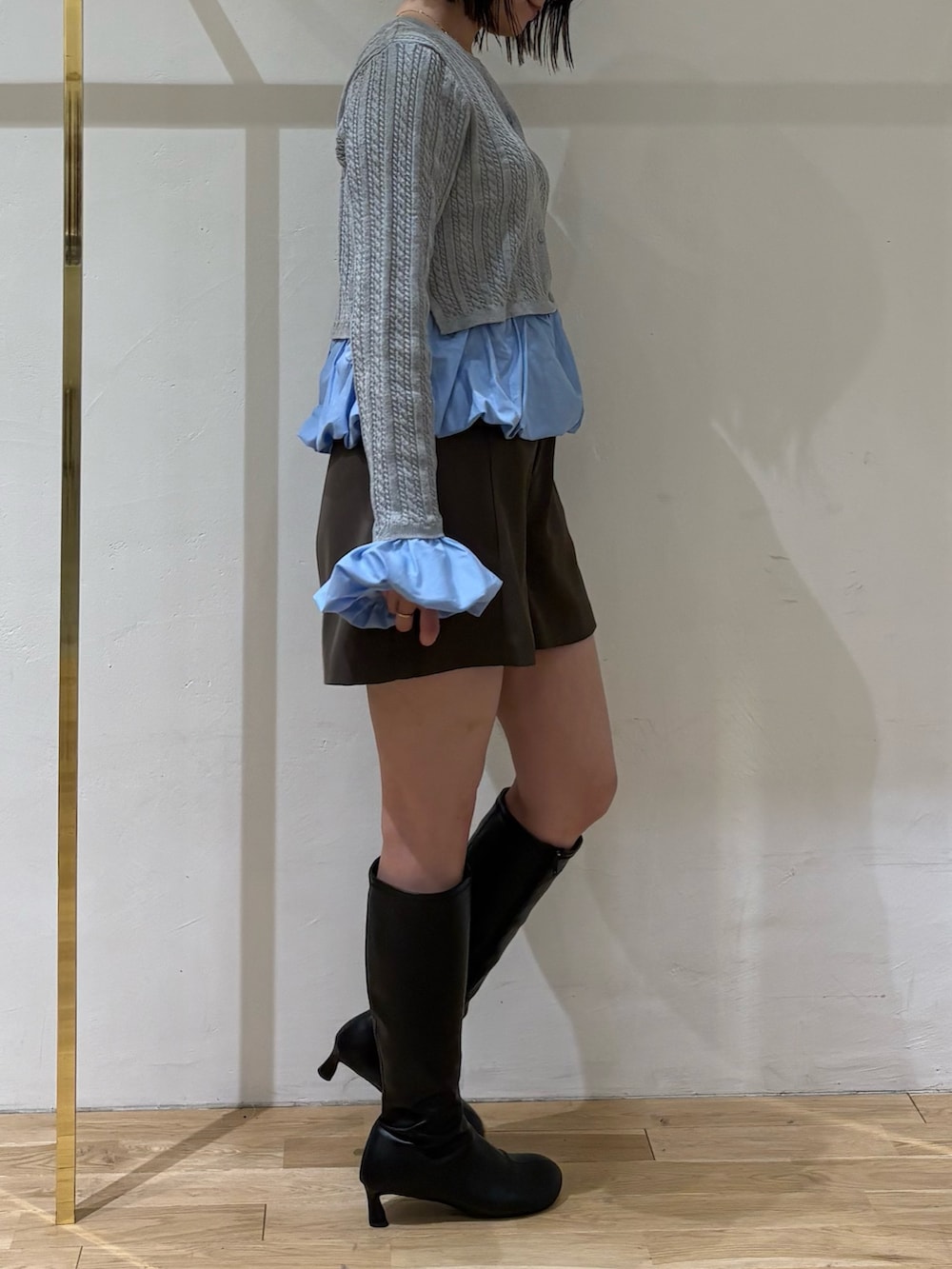 グレー系のニット/セーター、ブラウン系のその他パンツ、ブラック系のブーツを着用したレディースの秋コーディネートの2枚目の写真