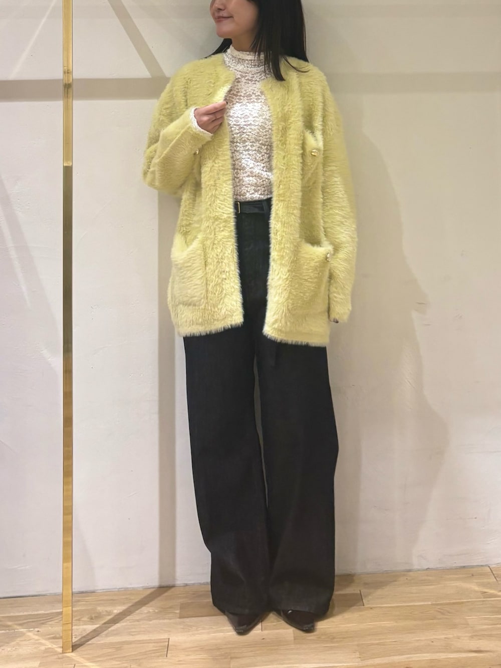 ブラック系のデニムパンツ、ホワイト系のTシャツ/カットソー、イエロー系のカーディガン/ボレロを着用したレディースの秋コーディネートの9枚目の写真