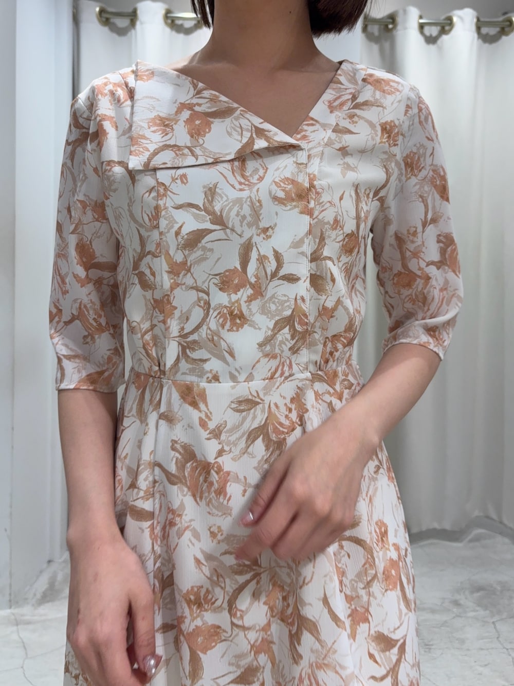 オレンジ系のワンピース、ホワイト系のパンプス、ホワイト系のカーディガン/ボレロを着用したレディースの冬コーディネートの3枚目の写真