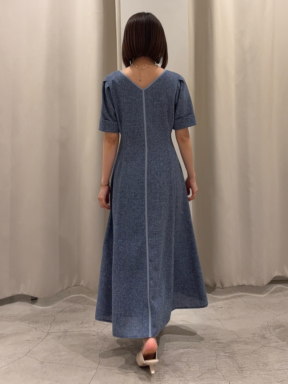 ブルー系のワンピース、ホワイト系のサンダル、ゴールド系のネックレスを着用したレディースの春コーディネートの3枚目の写真