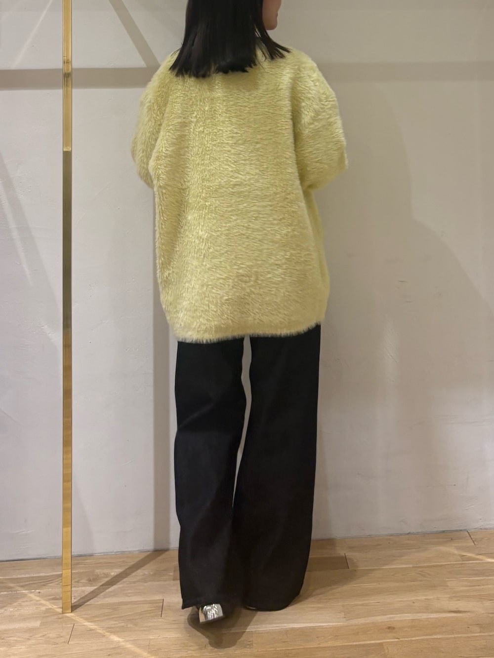 ブラック系のデニムパンツ、ホワイト系のTシャツ/カットソー、イエロー系のカーディガン/ボレロを着用したレディースの秋コーディネートの3枚目の写真