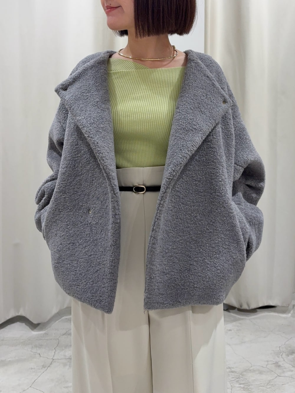 グリーン系のニット/セーター、グレー系のブルゾン、ホワイト系のその他パンツを着用したレディースの冬コーディネートの3枚目の写真