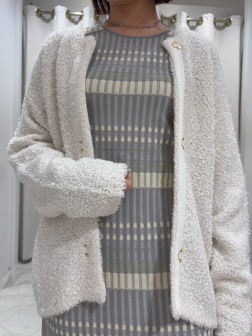 グレー系のワンピース、ホワイト系のカーディガン/ボレロ、ホワイト系のサンダルを着用したレディースの冬コーディネートの3枚目の写真