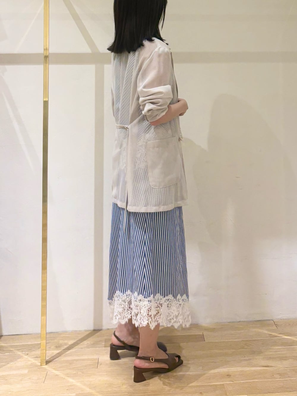 ブルー系のシャツ/ブラウス、ブルー系のスカート、ベージュ系のテーラードジャケットを着用したレディースの秋コーディネートの2枚目の写真