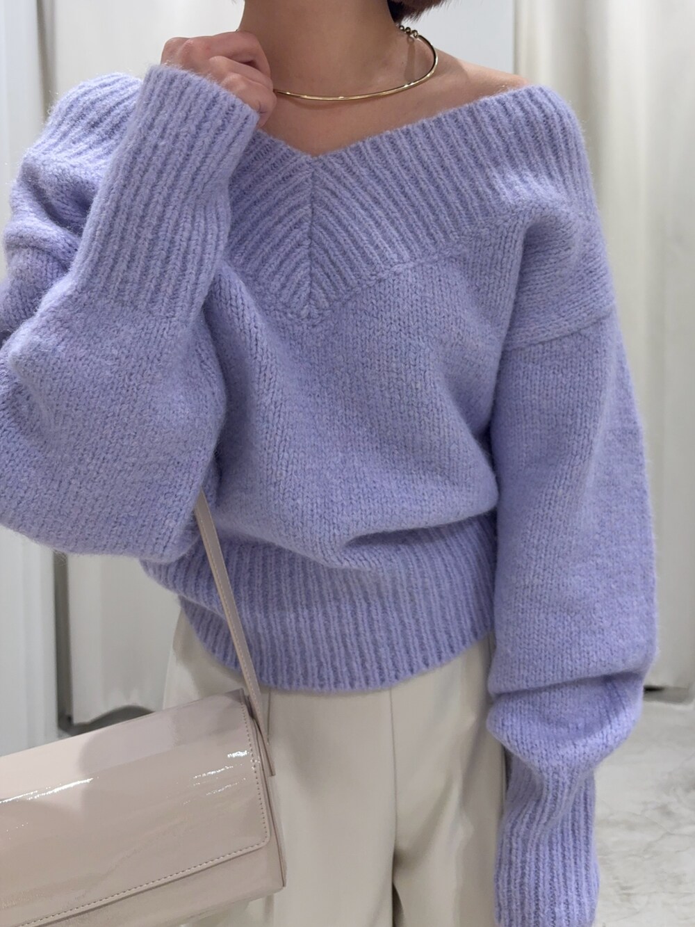 パープル系のニット/セーター、ホワイト系のその他パンツ、ホワイト系のショルダーバッグを着用したレディースの冬コーディネートの5枚目の写真