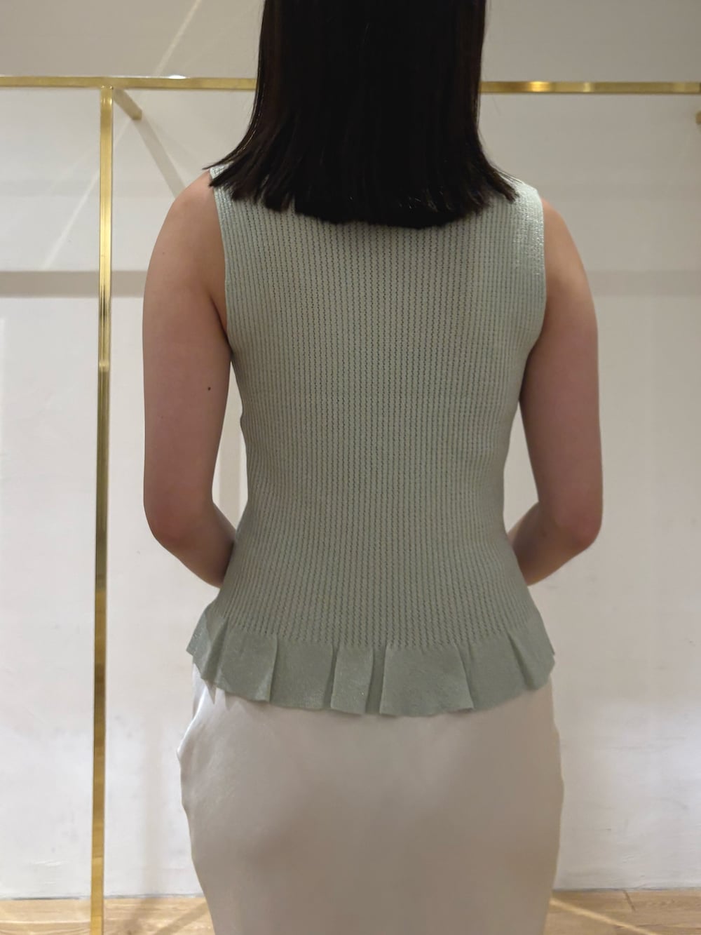 グリーン系のカーディガン/ボレロ、グリーン系のニット/セーター、ホワイト系のスカートを着用したレディースの夏コーディネートの4枚目の写真